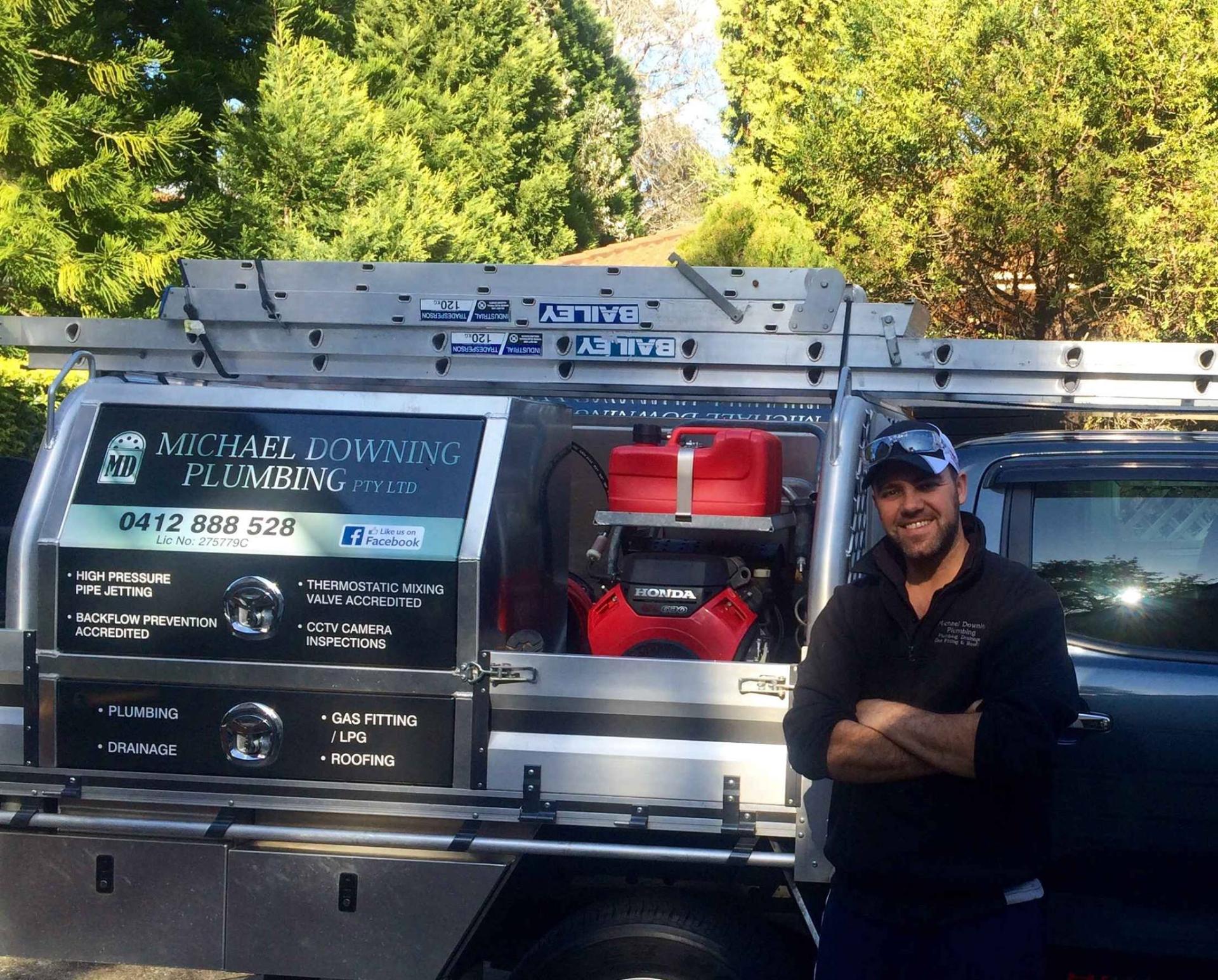 Friendly local plumber in Glenhaven standing beside service van